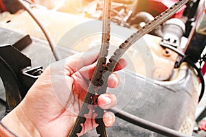 A mechanic hand holding a timing belt