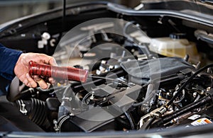 Mechanic hand using Tachometer checking engine of car