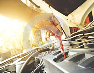 Mechanic hand was pulling oil dipstick to lube level checking