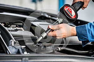 Mechanic Hands Filling Oil Into Car's Engine At Garage