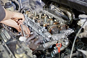 Mechanic hands tighten nut with wrench