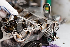 Mechanic hands tighten nut with wrench while repairing engine