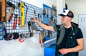 Mechanic in his workshop taking tools