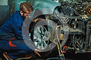 Mechanic Holding Car Tire At Garage.