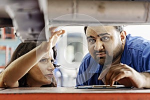 Mechanic holding explaining details and the car