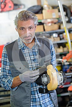mechanic holding strimmer engine