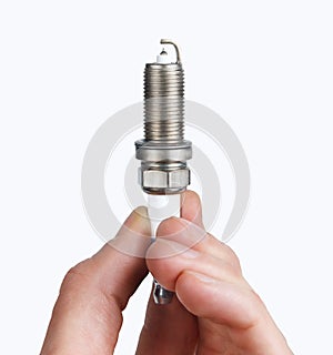 Mechanic holds a spare part spark plug in hand