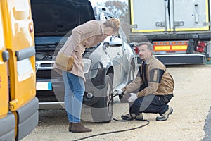 mechanic inflating womans car tyre roadside