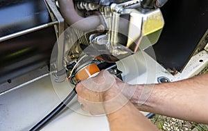 Mechanic Inspecting and replacing engine oil filter in stand up generator.