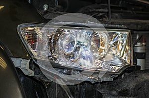 The mechanic installs the BI-LED lens in the headlight housing.
