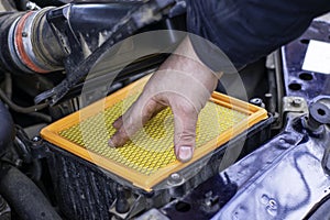 the mechanic installs a new filter element in the car's air filter