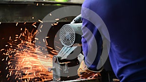 Mechanic labour man cuts heavy iron steel polishes metal grinder welding sparking industry worker