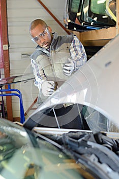 Mechanic leaning back to look car engine