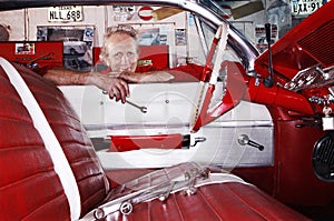 Mechanic Leaning Over Car Window In Garage