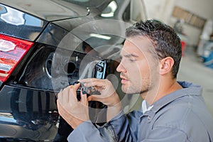 Mechanic looking at cables for car indicator