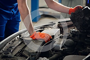 A mechanic is looking at a car engine. Close up