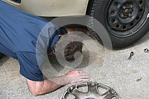 Mechanic Looks Under Car