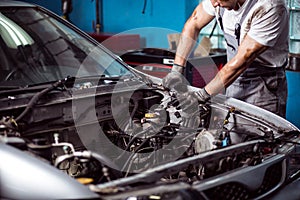 Mechanic maintaining car engine photo