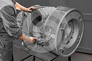 A mechanic maintains a marine gas turbine engine. Engineer repairs equipment. Turbine close-up.