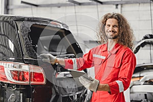 mechanic male happy smiling work insurance online claim accident car in garage auto workshop from internet tablet