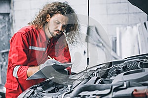 Mechanic male team staff worker working with car problem engine auto service check replace part list in garage