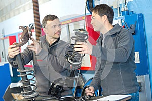 Mechanic and male trainee with dampers