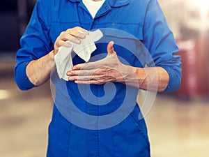 Mechanic man or smith with wipe at car workshop