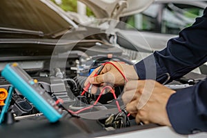Mechanic man working on the engine of the car in the garage.Car service and maintenance,Repair service.Checks car engine under the