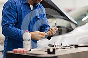 Mechanic man with wrench repairing car at workshop