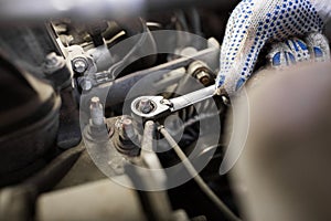 Mechanic man with wrench repairing car at workshop