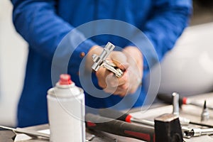 Mechanic man with wrench repairing car at workshop