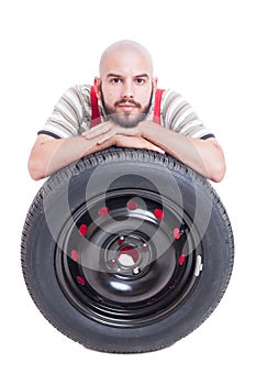 Mechanic and new car wheel tire isolated on white