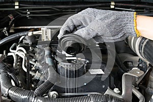 A mechanic is opening the oil cap from a car engine.