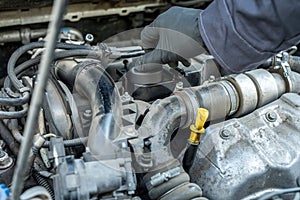 Mechanic is opening the oil cap for change of oil from a car engine