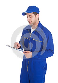 Mechanic In Overall Writing On Clipboard