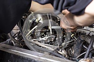 A mechanic performing diagnostics and repairs of a car, the front and background background is blurred with bokeh effect