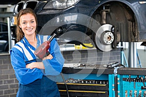 Mechanic With Pneumatic Wrench Standing By Car