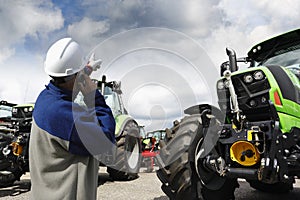 Mechanic pointing at large farming tractors