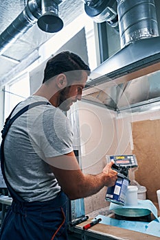 Mechanic pouring paint from container to bucket on scales