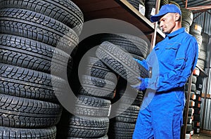 Mechanic pulls tire from the tyre store warehouse