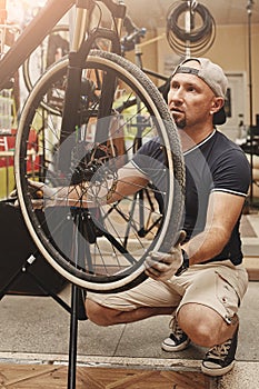 Mechanic repairing bicycle in his workshop