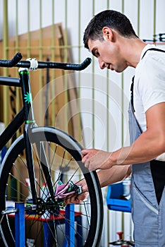 Mechanic repairing bicycle in his workshop