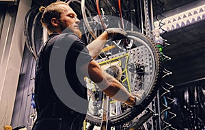 Mechanic repairing bicycle wheel tire in a workshop.