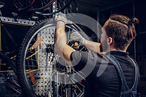 Mechanic repairing bicycle wheel tire in a workshop.