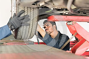 Mechanic Repairing Car Tire In Auto Repair Shop