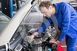 Mechanic repairing a car in a workshop or garage