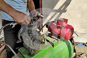 A mechanic repairing a cylindrical motor