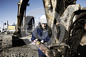 Mechanic repairing hydraulics on a bulldozer