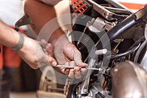 Mechanic Repairing A Motorbike Engine In A Workshop.