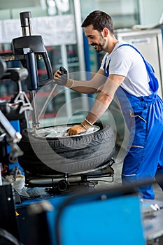 Mechanic repairman balancing car wheel